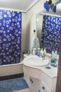 uma casa de banho com um lavatório e uma cortina de chuveiro em Beach House in Vilamoura: Terrace+pool em Vilamoura