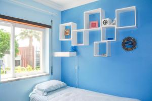 um quarto azul com uma cama e uma janela em Beach House in Vilamoura: Terrace+pool em Vilamoura