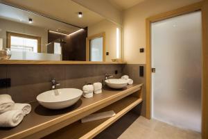 a bathroom with two sinks and a large mirror at Haus Gregori in Caldaro