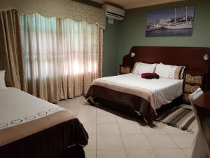 um quarto com 2 camas e uma grande janela em Rainbow Guest House and Tours em Uitenhage