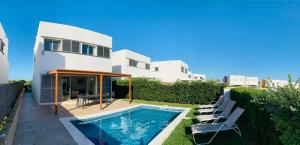 a villa with a swimming pool and a house at Villa Lauvic in Cala en Bosc