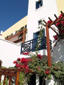 a white building with flowers and a blue balcony at Kalimera Hotel in Akrotiri