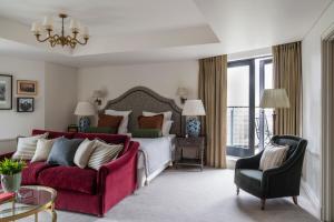 a bedroom with a bed and a red couch at The Gleneagles Hotel in Auchterarder