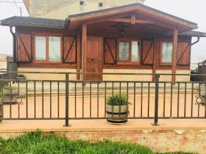 een huis met een veranda met een zwart hek bij Casa-Apartamento Madera y Sol in Lubia