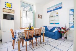 a living room with a table and chairs and a blue couch at La casa del capitano in Atrani