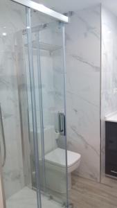 フエンヒロラにあるAurinko 2 Magnifico Apartamento con Vistas al Marのバスルーム(トイレ、ガラス張りのシャワー付)