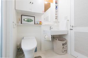 a white bathroom with a toilet and a sink at Tyler's Vacation Villa Osaka Castle 泰楽居 大阪城 in Osaka +22 photos