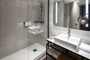 a bathroom with a sink and a mirror and a shower at Hotel Mercure Poznań Centrum in Poznań