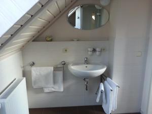 a bathroom with a sink and a mirror and towels at Scheunenhaus Kienspan in Tornitz