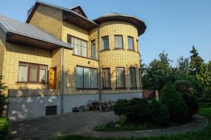 une grande maison jaune avec une terrasse en face de celle-ci dans l'établissement A&L private rooms in Kaunas, à Kaunas