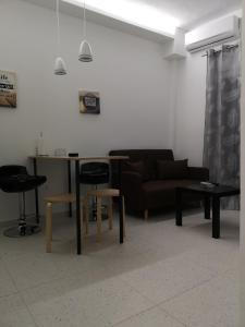 a living room with a couch and a table and chairs at Dimitris House 7 in Thessaloniki
