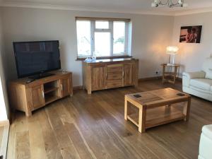 a living room with a flat screen tv and a couch at The Bungalow in Billericay