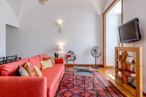 a living room with a red couch and a tv at Lisbon Downtown Apartment Figueira in Lisbon