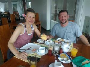 un homme et une femme assis à une table qui mangent de la nourriture dans l'établissement Saprin Beach By Travel Corners, à Uswetakeiyawa