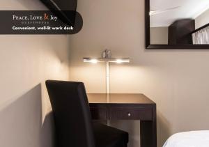 a desk with a black chair and a mirror at Peace Love and Joy Self Catering Units in Port Elizabeth