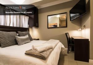 a bedroom with a bed and a desk and a mirror at Peace Love and Joy Self Catering Units in Port Elizabeth