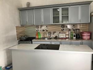 a kitchen with white cabinets and a counter top at Guest House Luka in Danisparauli