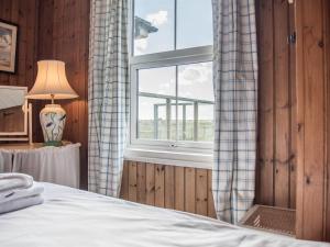 1 dormitorio con cama y ventana en Fairhaven, en Thorpeness