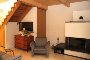 een woonkamer met een stoel en een televisie bij Haus Sonate in Bad Schandau