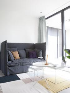 a living room with a gray couch and a table at B&B StudioLKE in Heeze