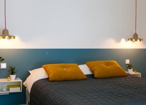 a bedroom with a bed with two yellow pillows at B&B StudioLKE in Heeze
