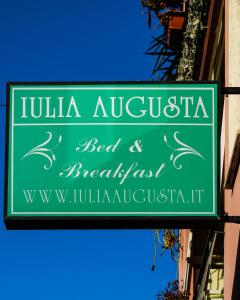 a green sign hanging from the side of a building at B&B Iulia Augusta in Albenga