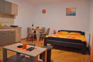 a bedroom with a bed and a kitchen with a table at Apartman Radmanovac in Vrnjačka Banja