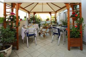 een patio met een tuinhuisje met tafels en stoelen bij B&B Iulia Augusta in Albenga