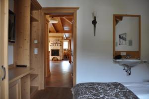 a room with a bed and a sink and a hallway at Penthouse Kitzpanorama in Kaprun