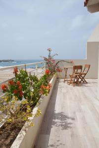 a balcony with flowers and a view of the beach at Ca Marta Penthouse in Sal Rei