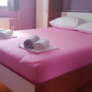 two towels are sitting on a pink bed at Pool Apartment Knezevic in Novalja +18 photos