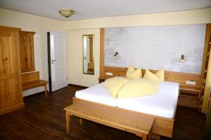 ein Schlafzimmer mit einem großen weißen Bett mit gelben Kissen in der Unterkunft Gasthaus Sonne in Altusried