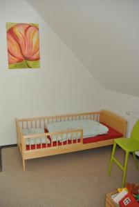 a bedroom with a wooden bed and a green chair at FEWO Elbe Weser in Hipstedt