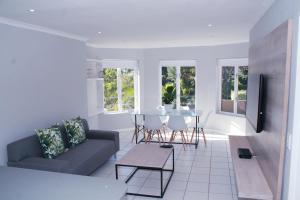 ein Wohnzimmer mit einem Sofa und einem Tisch in der Unterkunft Beautiful Bell Rock - partial inverter in Plettenberg Bay