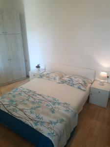 sypialnia z łóżkiem z niebiesko-białym kocem w obiekcie Apartments Hropić w mieście Lastovo