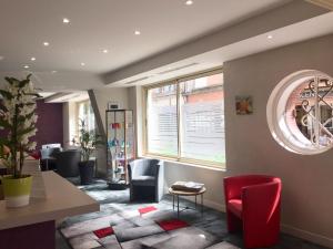 a waiting room with chairs and a table and windows at Hotel Chiffre in Albi