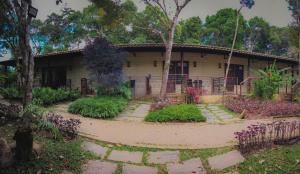 uma casa com um jardim em frente em Hotel Vale das Nuvens em Guaramiranga