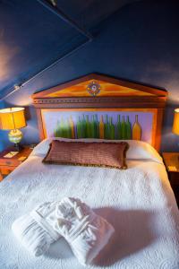 a bedroom with a white bed with a wooden headboard at McMenamins Grand Lodge in Forest Grove