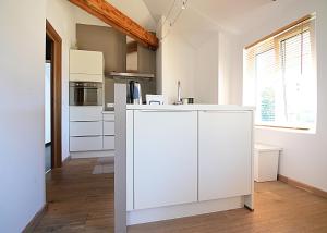 a kitchen with white cabinets and a kitchen island at La Citadine-Gîte citadin in Neufchâteau