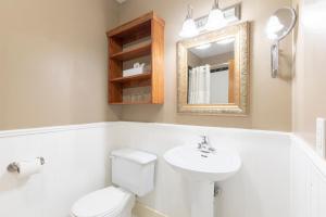 a bathroom with a toilet and a sink and a mirror at Unilofts Grande-Allée in Quebec City