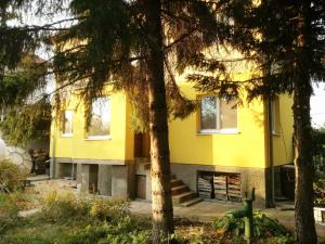 una casa amarilla con árboles delante de ella en Стаи за гости "Дом Градина Вита" / Guest Rooms “House Vita Garden”, en Sofía