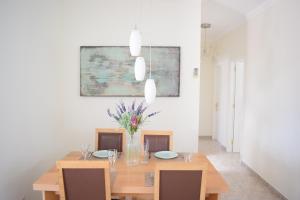 une salle à manger avec une table en bois et des fleurs. dans l'établissement Villa Imogen with NEW HEATED SWIMMING POOL, à Playa Blanca