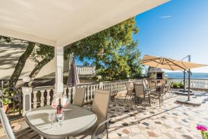 a patio with a table and chairs and an umbrella at Apartment Crikvenica 7 in Crikvenica