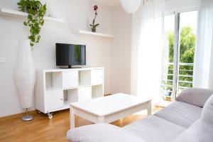 マラガにあるCharming apartment in Pedregalejoの白いリビングルーム(テレビ、ソファ付)