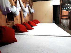 fila de camas en una habitación con almohadas rojas en Dzay house homestay, en Sa Pa