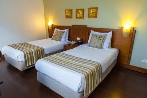 a hotel room with two beds and two lamps at Quality Porto Alegre in Porto Alegre