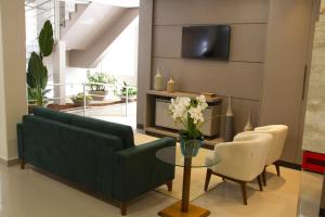 ein Wohnzimmer mit einem Sofa, einem Tisch und Stühlen in der Unterkunft Presidente Hotel in Passos