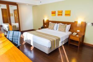 a hotel room with a large bed and a telephone at Quality Porto Alegre in Porto Alegre