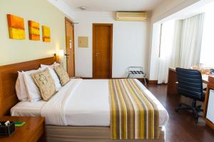 a hotel room with a bed and a desk at Quality Porto Alegre in Porto Alegre