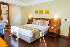 a hotel room with a large bed and a telephone at Quality Porto Alegre in Porto Alegre